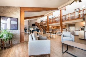 a lobby with a staircase and tables and chairs at AmericInn by Wyndham Hutchinson in Hutchinson