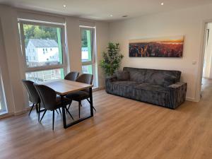 a living room with a couch and a table and chairs at Idar Apartments 11 in Idar-Oberstein