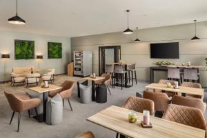 a restaurant with tables and chairs and a bar at Ramada by Wyndham Essen in Essen