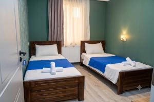 two beds in a small room with green walls at Hostel Tsalka in Tsalka