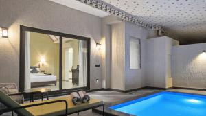 a room with a swimming pool and a bedroom at Aamba Bagh Resort Kumbhalgarh in Kumbhalgarh +27 photos