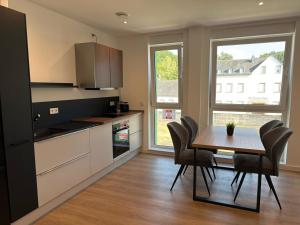 a kitchen with a table and chairs and a dining room at Idar Apartments 11 in Idar-Oberstein