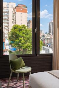 a bed and a chair in a room with a window at V-one Hotel - Ningxia No. 2 Inn in Taipei
