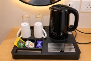 a black coffee maker sitting on top of a table at Hotel SSV Suites Premium Near HItech City, Madhapur in Hyderabad