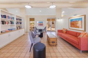 a living room with a red couch and chairs at Outback Lodge in Ayers Rock