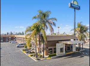 a hotel with palm trees in front of a parking lot at Days Inn Merced / Yosemite Area in Merced