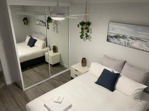 a small bedroom with a bed and a mirror at Seaside Breezes with Wi-fi in Slade Point