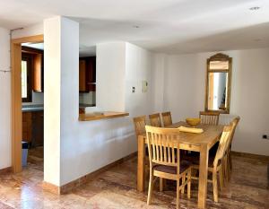 a kitchen and dining room with a wooden table and chairs at Luna-Villa de Riviera with Sea-View in Mijas Costa