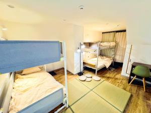 a room with two bunk beds and a desk at Maison Stay Kobe in Kobe +16 photos