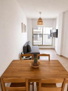a living room with a wooden table and a couch at El HierroStay Appartments - La Chalana & El Remo in La Restinga