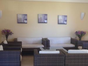 a waiting room with couches and flowers on the wall at Anita Apartments in Ialyssos