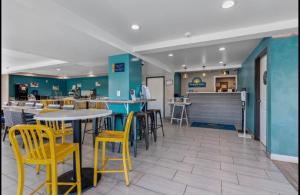 a restaurant with yellow chairs and tables and a counter at Days Inn Merced / Yosemite Area in Merced
