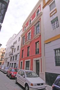 une voiture blanche garée devant une rangée de bâtiments dans l'établissement Apartamentos Living Sevilla Centro Maestranza, à Séville