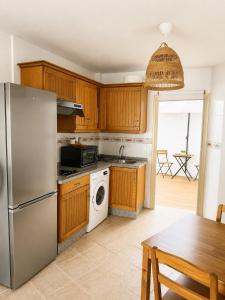 a kitchen with a stainless steel refrigerator and a table at El HierroStay Appartments - La Chalana & El Remo in La Restinga