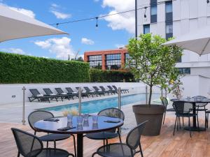 a patio with tables and chairs and a pool at Ibis Styles Toulouse Labège in Labège +133 photos
