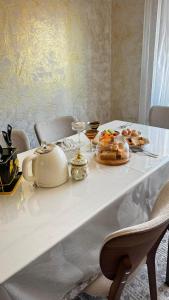 a white table with food and drinks on it at Erkaiym Guest house in Bokonbayevo +29 photos