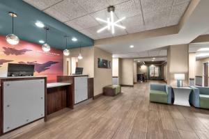 an office lobby with a desk and chairs at La Quinta by Wyndham Midwest City - Tinker AFB in Midwest City
