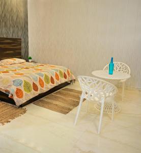 a bedroom with a bed and a table and a chair at Royal Orchid in Faridabad