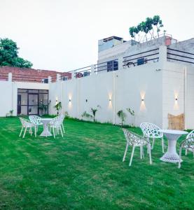 a group of chairs and a table in the grass at Royal Orchid in Faridabad