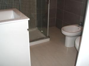 a bathroom with a shower and a toilet and a sink at Charming Apartment in Troia, Garden View, 60 sqm in Troia