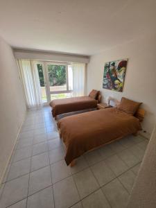 a bedroom with two beds and a window at Appartement 188m2 in Crans-Montana