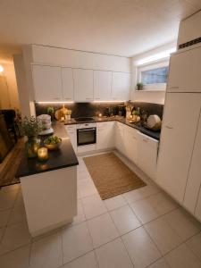 a kitchen with white cabinets and a black counter top at Appartement 188m2 in Crans-Montana