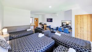 a hotel room with two beds and a table and chairs at The Cottage Motor Inn Albury CBD in Albury