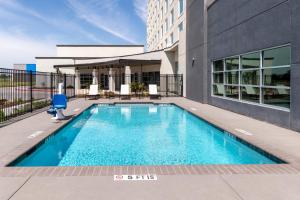 a swimming pool in front of a building at Doubletree By Hilton Midland West Loop I-250 in Midland
