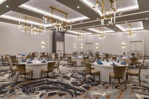 a large room with tables and chairs and chandeliers at Doubletree By Hilton Midland West Loop I-250 in Midland