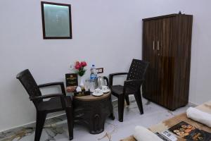 a living room with three chairs and a table and a cabinet at Hotel New Residency Ayodhya in Ayodhya +37 photos