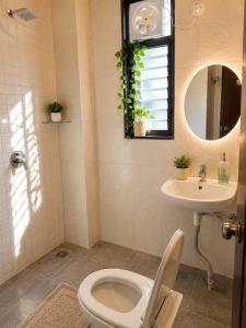 a bathroom with a toilet and a sink and a mirror at LuxeBnb - Hill View 2bhk Baner in Pune