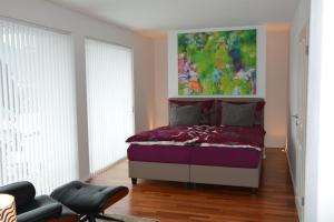 ein Schlafzimmer mit einem Bett mit einem Gemälde darüber in der Unterkunft Designerwohnung Maria Plain in Radeck