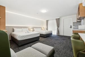 a hotel room with two beds and a couch at Frankston Bay Motel in Frankston