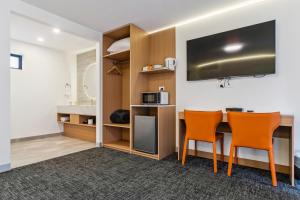 a room with a table and two chairs and a microwave at Frankston Bay Motel in Frankston