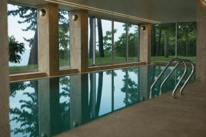 a swimming pool with a reflection of trees in the water at Buknari Hotel in Buknari