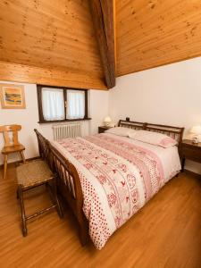 a bedroom with a large bed with a wooden ceiling at Dolomiti House in Pinzolo
