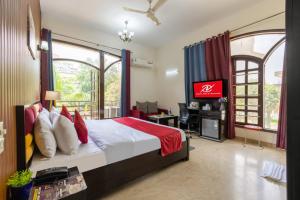 a bedroom with a bed and a tv in it at Nook Inn & Suites - 2 Min Walk From MG ROAD METRO in Gurgaon