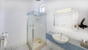 a bathroom with a sink and a glass shower at The Cottage Motor Inn Albury CBD in Albury +40 photos