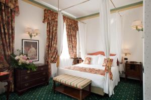 a bedroom with a bed and a canopy bed at Hotel Victoria & Iside Spa in Turin +82 photos