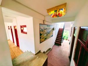 a hallway with a staircase and a painting on the wall at The Kailash Glint in Kalpa
