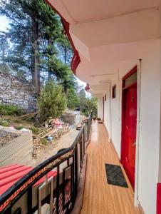 a house with a red door on a balcony at The Kailash Glint in Kalpa +9 photos