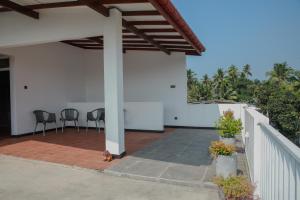 a covered patio with chairs and a fence at Aranya Heights Luxury 7 Pax Home in Wattala