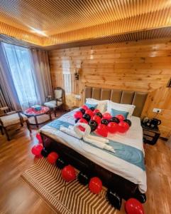 a bedroom with a large bed with red balls on it at The Kailash Glint in Kalpa