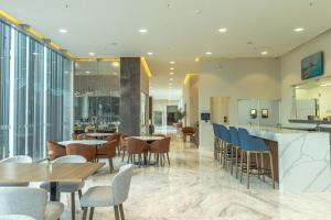 a restaurant with tables and chairs and windows at Holiday Inn Navojoa by IHG in Navojoa