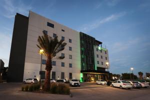 a building with cars parked in a parking lot at Holiday Inn Navojoa by IHG in Navojoa