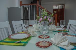 a table with plates and glasses and a vase of flowers at Aranya Heights Luxury 7 Pax Home in Wattala