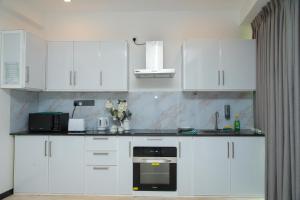 a kitchen with white cabinets and a black oven at Aranya Heights Luxury 7 Pax Home in Wattala +15 photos