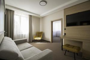 a living room with a couch and a flat screen tv at Hotel Slezská in Muglinov