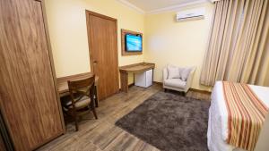 ein Hotelzimmer mit Bett und Schreibtisch in der Unterkunft Hotel Alles Blau in Pelotas + 9 Fotos