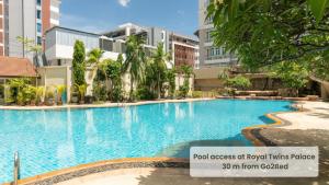 a large swimming pool in a city with buildings at Go2bed Pattaya Hotel in Pattaya